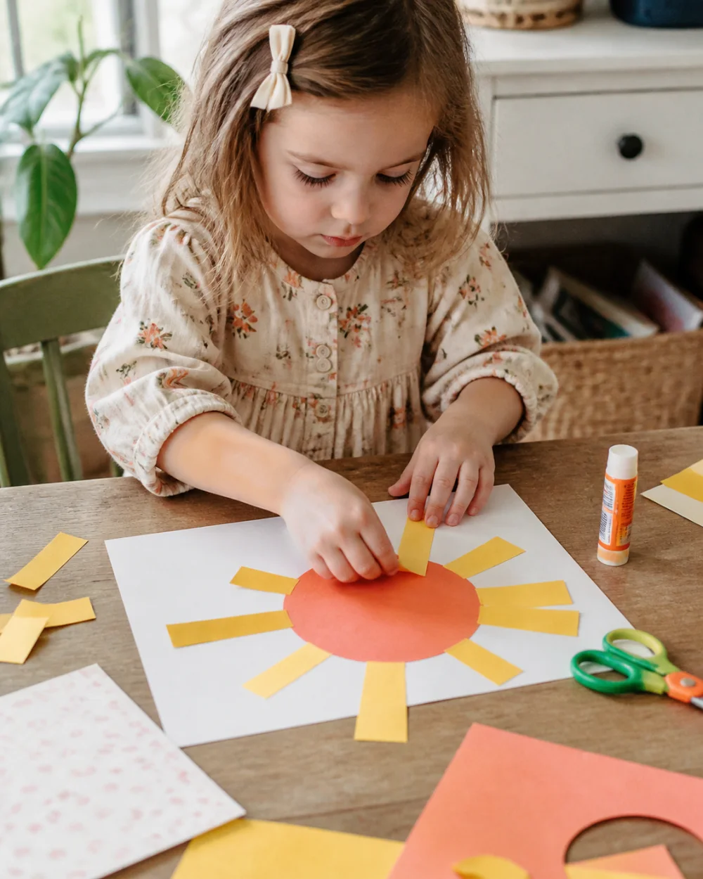 Young child making a cheerful paper sun craft